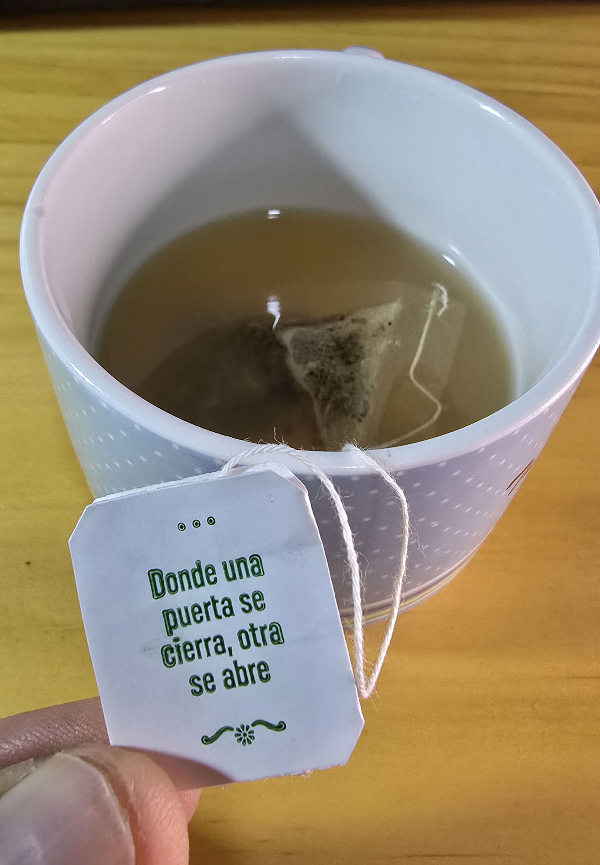 Teacup with label 'When one door closes, another opens'